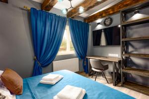 a bedroom with a blue bed and a desk at Karlovy Charme Inn by Rentez in Karlovy Vary