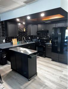 a kitchen with black appliances and black cabinets at Luxe Waterfront home near beach in Fort Myers
