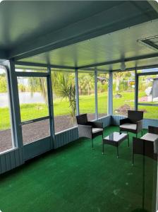 a room with chairs and a table and windows at Luxe Waterfront home near beach in Fort Myers