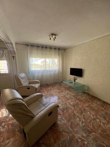 a living room with couches and a table and a television at Piso Completo cerca de Artes Y Ciencias in Valencia