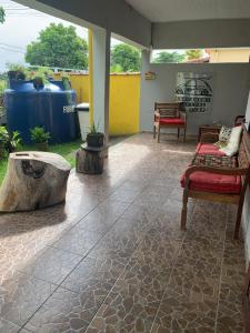 a patio with chairs and a stone floor at SUITES Recanto do DO Mar in Saquarema