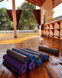 a group of rolled up yoga mats on a wooden floor at YOGA SHACK in Arugam Bay