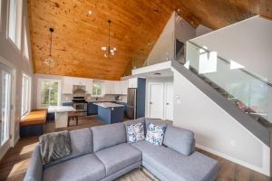 Riverside Retreat: Maazah Cottage في Fort Coulonge: غرفة معيشة مع أريكة ومطبخ