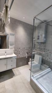 a bathroom with a shower and a toilet and a sink at Calipso Dushanbe Hotel in Dushanbe