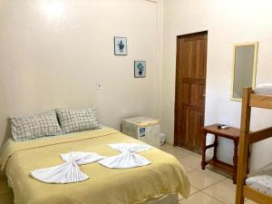 - une chambre avec un lit et des serviettes dans l'établissement Pousada Cama e Café, à Presidente Figueiredo