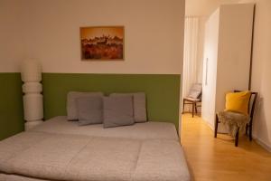 a bedroom with a bed with a green headboard at Altes Pfarrhaus in Oberhausen