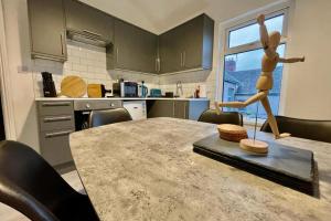 a kitchen with a table with a sculpture on it at Sophia's Retreat - 2 Floor 4 Bed Apartment - Newport - Coastal Getaway in Newport