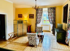 d'un salon avec une table, des chaises et une fenêtre. dans l'établissement Schloss Moosburg Gästehaus, à Moosburg