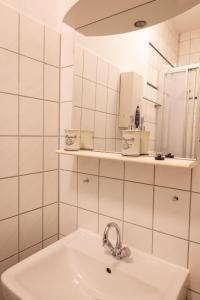 a white bathroom with a sink and a mirror at Altes Pfarrhaus in Oberhausen