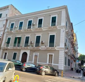 een wit gebouw met auto's ervoor geparkeerd bij La Casetta di Vale in Taranto