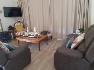 a living room with two couches and a coffee table at Oorlogs Kloof Mountain Retreat Montagu in Montagu