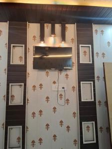 a wall with framed pictures on it with a light at सुभद्रा guest house in Ayodhya