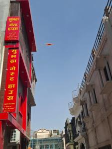 सुभद्रा guest house في Ayodhya: مجموعة مباني عليها لافتات حمراء