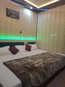 un grande letto in una stanza con luci verdi di सुभद्रा guest house a Ayodhya