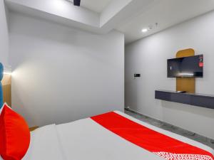 a bedroom with a bed and a flat screen tv at OYO 82103 Hotel Galaxy in Surat