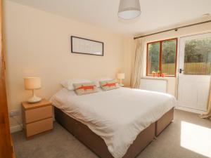 a bedroom with a large white bed and a window at Poplar Farm Studio in Chester