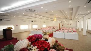 - une salle de banquet avec des tables et des chaises rouges et blanches dans l'établissement SÀI GÒN - BẠC LIÊU Hotel, à Bạc Liêu