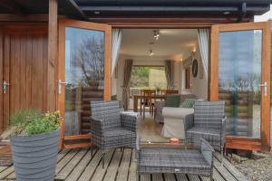 a porch with wicker chairs and a living room at Tressa, Tor Down Quarry in Bodmin