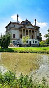 un antiguo edificio junto a un cuerpo de agua en Villino Verde en Mira