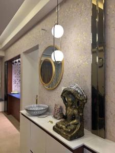 a bathroom with a statue on a counter with a mirror at Cozy 1 BHK apartment in Bhartiya City in Yelahanka