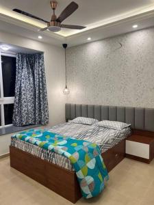 a bedroom with a bed and a window at Cozy 1 BHK apartment in Bhartiya City in Yelahanka