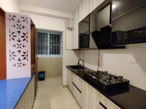 a kitchen with a stove and a counter top at Cozy 1 BHK apartment in Bhartiya City in Yelahanka