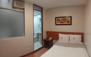 Dormitorio pequeño con cama y espejo en My Rouse Hotel, en Chiclayo