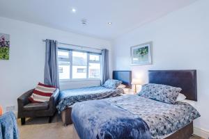 a bedroom with two beds and a chair and a window at Contractor Accommodation Barnetby in Barnetby le Wold
