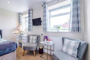 a bedroom with a bed and a chair and a desk at Holcombe Guest House in Barnetby le Wold