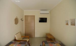Habitación pequeña con 2 camas y TV. en Kallichoron 2, en Kavala