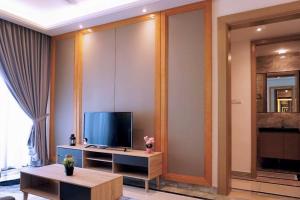 een woonkamer met een televisie en een tafel bij R&F Summer Suite 2B2B in Johor Bahru