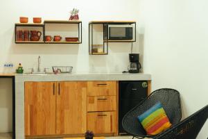 uma cozinha com um lavatório, um micro-ondas e uma cadeira em Casa Don José: GRANADAS em Oaxaca City