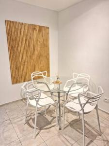 une table et des chaises en verre dans une pièce dans l'établissement Le Bleu Apartamento, à Buenos Aires
