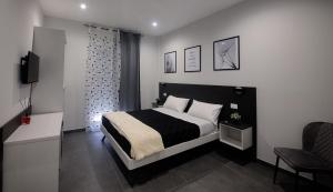 1 dormitorio con 1 cama en blanco y negro y 1 silla en Terra Mia Fonseca B&B en Nápoles