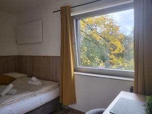 a room with a window with a bed and a tree at SP Hotel Mettmann in Mettmann