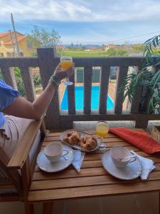 una persona bebiendo un vaso de zumo de naranja en una mesa en A CASA DE SISAN, en Ribadumia