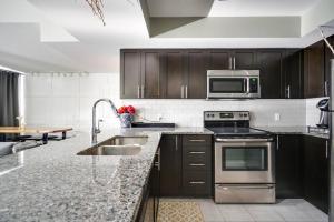 a kitchen with a sink and a stove top oven at Executive Condo (boutique hotel-like) in Ottawa