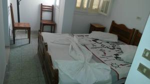a bedroom with a bed with white sheets at Hotel de la plage in Bizerte