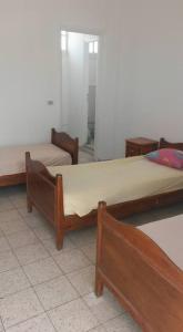 un grupo de 3 camas en una habitación en Hotel de la plage en Bizerte