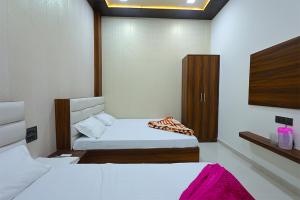 a hotel room with two beds and a tv at Shiv Residency in Mathura
