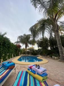 a swimming pool with two lounge chairs in front of a resort at Casa VENTA RUIZO in Lorca