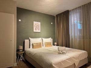 ein Schlafzimmer mit einem großen Bett und einer grünen Wand in der Unterkunft High Street Apartments in Zandvoort