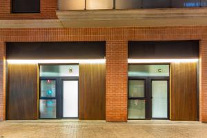 Deux entrées pour un bâtiment en briques avec trois portes dans l'établissement Suite Deluxe Valencia - AIORA Apartments, à Valence