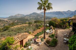 uma casa com uma palmeira e uma mesa e cadeiras em Ca's Xorc Luxury Retreat - ADULTS ONLY em Sóller