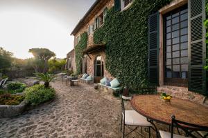 a patio with a table and chairs next to a building at Ca's Xorc Luxury Retreat - ADULTS ONLY in Sóller