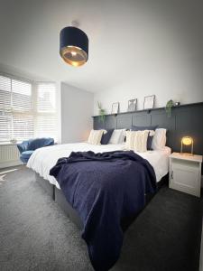 um quarto com uma cama grande e uma cabeceira azul em Campbells Crib em Kent