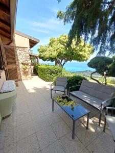 um pátio com um sofá e uma mesa e o oceano em A Casa di Matilde em Gioiosa Marea