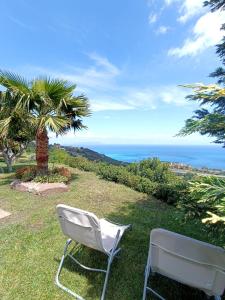 een witte stoel op het gras bij de oceaan bij A Casa di Matilde in Gioiosa Marea