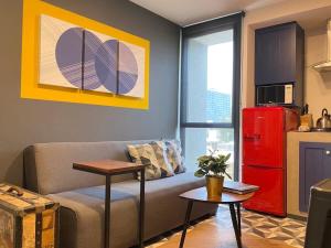 Departamento de Gran Ubicación, pegado a la CONDESA في مدينة ميكسيكو: غرفة معيشة مع أريكة وثلاجة حمراء