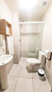 uma casa de banho branca com um WC e um lavatório em Pousada Mima em Gramado